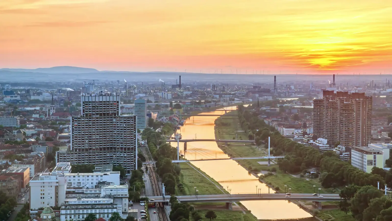 Luftbild von Mannheim mit dem Neckar im Licht der untergehenden Sonne