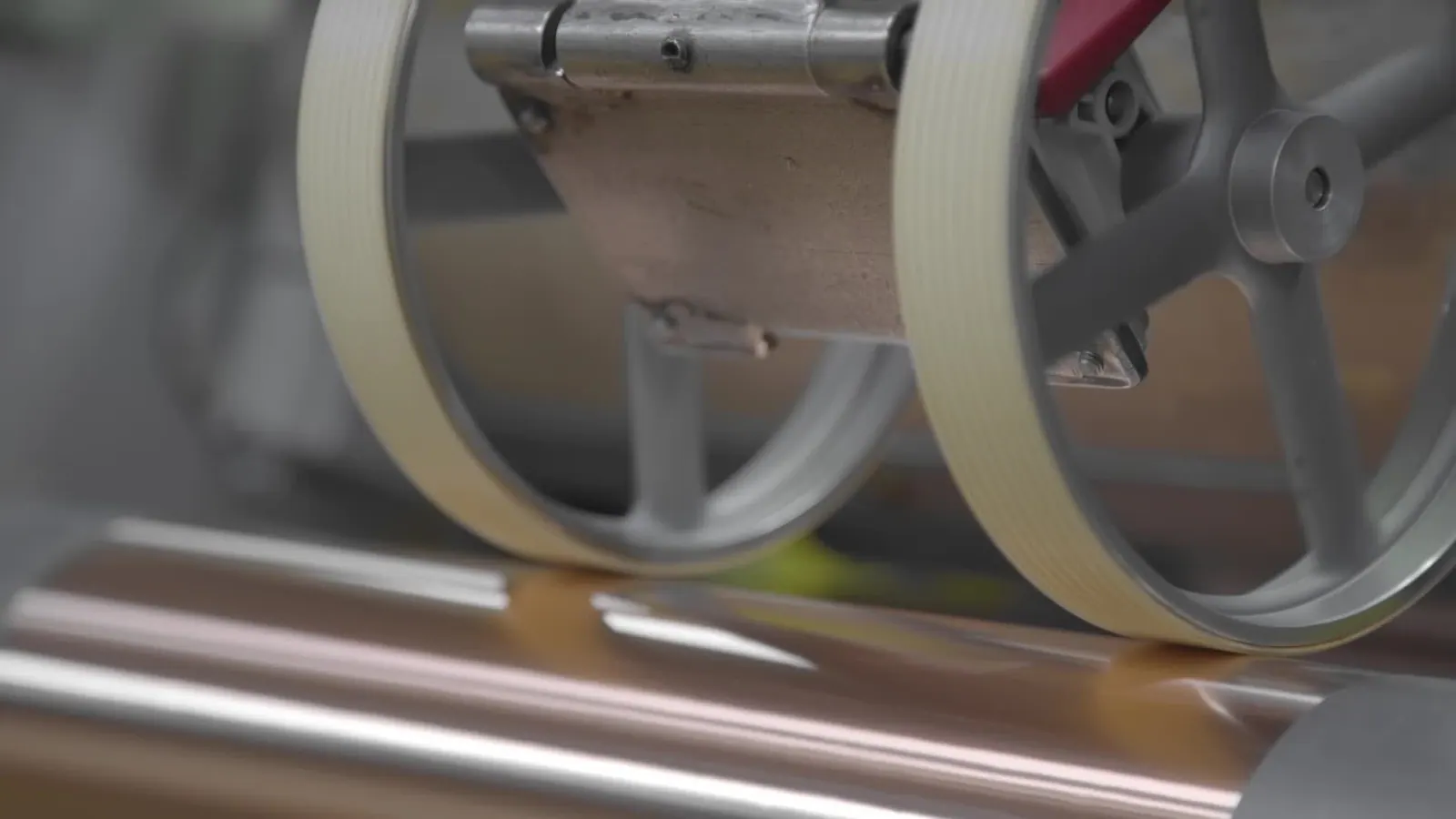 Klebebandrolle läuft über die Rollen einer Maschine