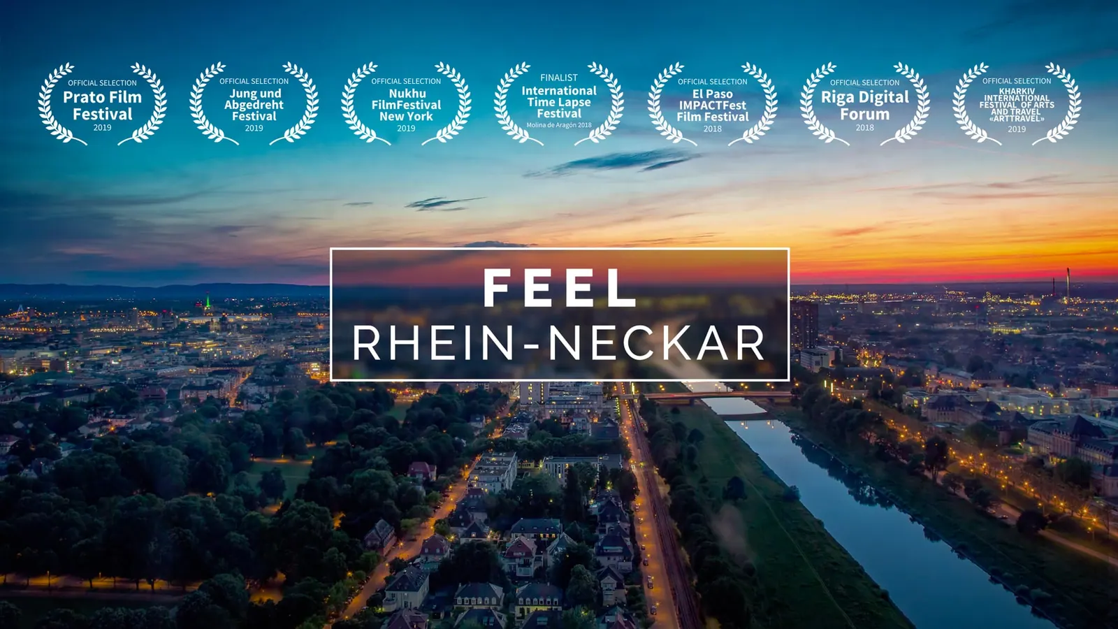 Abendliches Luftbild einer beleuchteten Stadt am Fluss, Titel „Feel Rhein-Neckar“ mit Festival-Lorbeeren