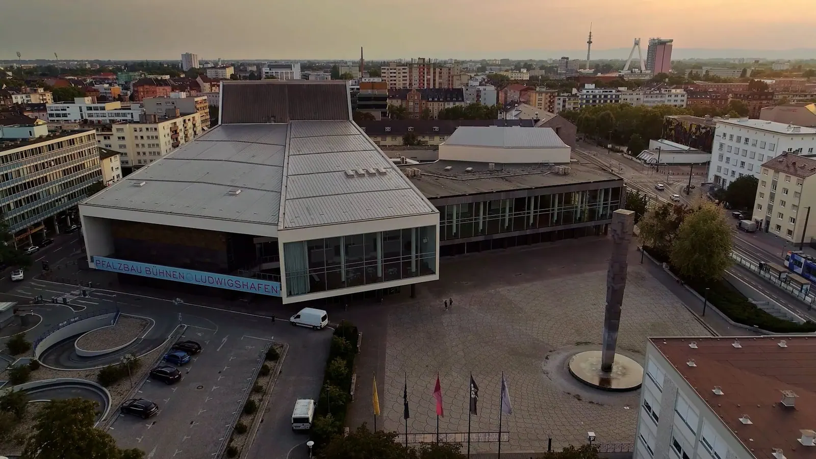 Luftbild des Pfalzbaus in Ludwigshafen mit Vorplatz und Stadtpanorama in der Dämmerung