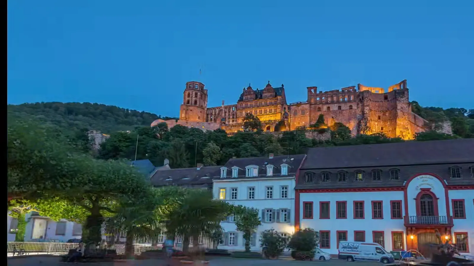Beleuchtetes Heidelberger Schloss über dem Karlsplatz zur blauen Stunde