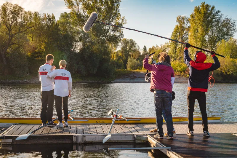 Außendreh am Flusssteg mit Kamera, Tonangel und zwei Ruderern