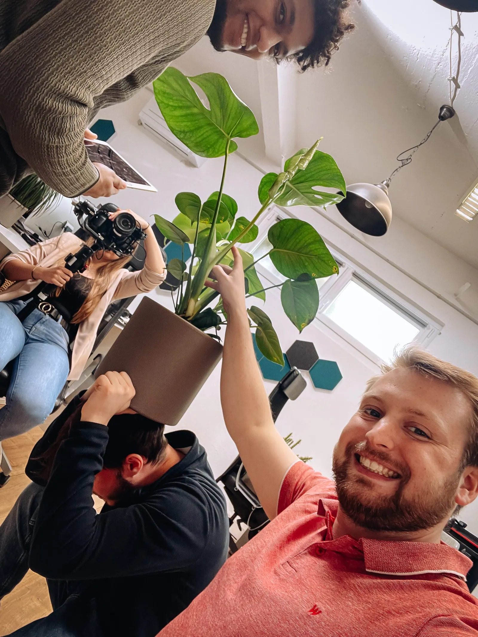 Northwind-Teammitglieder posieren beim Dreh im Büro mit Kamera und Zimmerpflanze