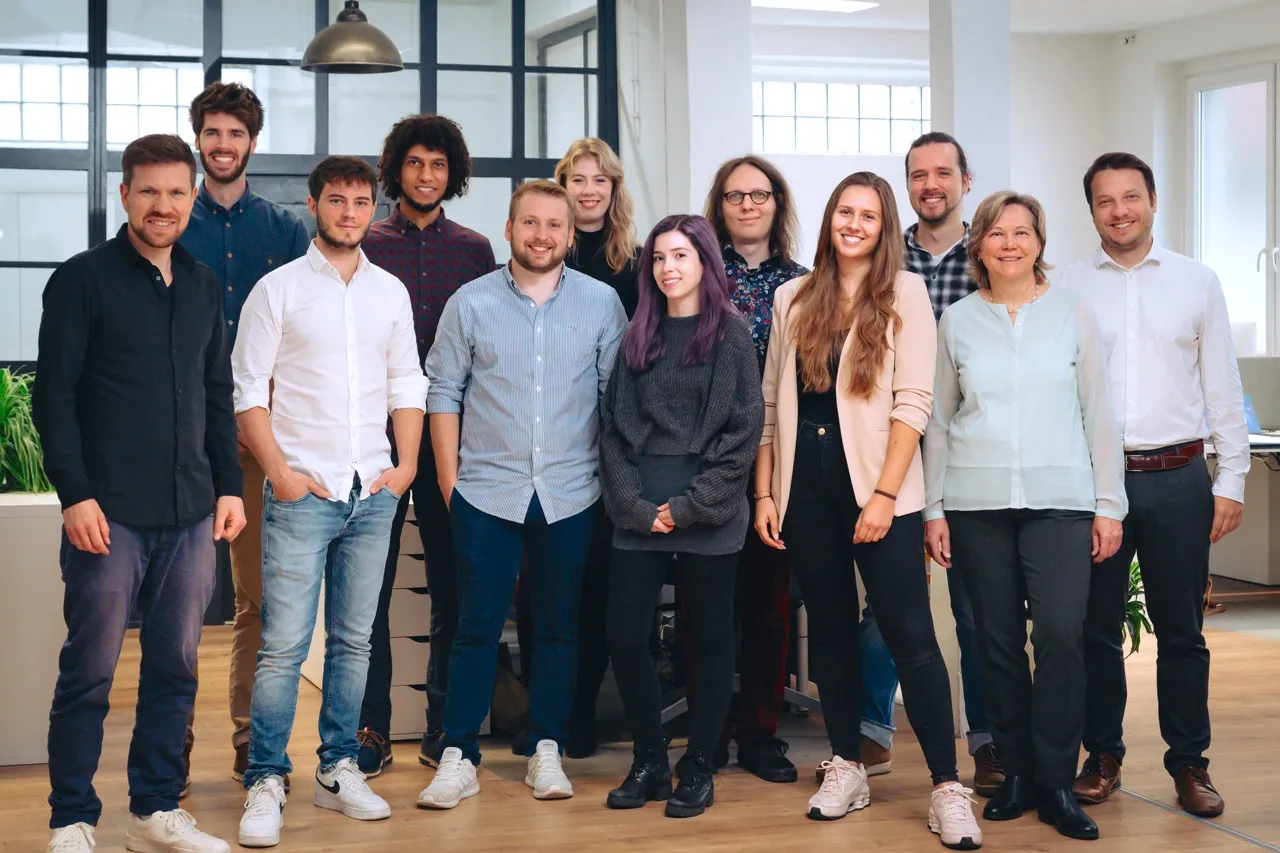 Gruppenfoto des Northwind-Teams in hellen Büroräumen mit Fensterfront